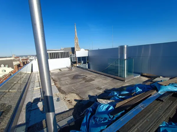 Vorher – Dach 1010 Wien mit Holzbrettern und blauen Säcken