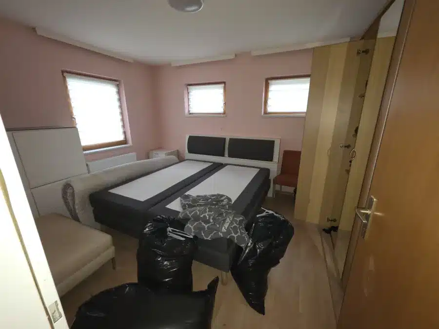 Zimmer in Achau vor der Entrümpelung mit Couch und Trainingsgerät